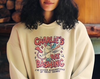 May include: A cream colored sweatshirt with a cartoon rat holding a baseball bat and the text "Charlie's Rat Bashing I've killed generations of these things".