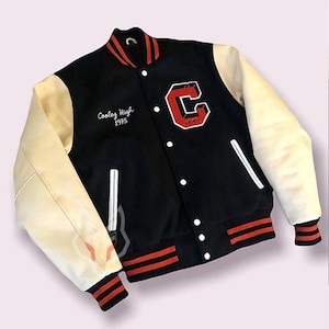 May include: Black varsity jacket with cream sleeves. It has a large red "C" patch and the text "Cooley High 1975". The jacket features red and white striped trim on the collar, cuffs, and waist.