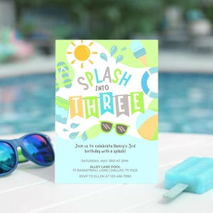 May include: A birthday party invitation with the words "Splash into Three" and a sun, sunglasses, and water splashes graphic. The invitation is on a white surface with blue sunglasses and a blue ice lolly.