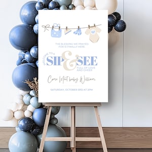 Puede incluir: Un letrero de baby shower sobre un caballete con un arco de globos. El letrero dice "Welcome to a Sip & See" con el texto "Come Meet baby William" y los detalles del evento. El letrero presenta ilustraciones temáticas de bebés.