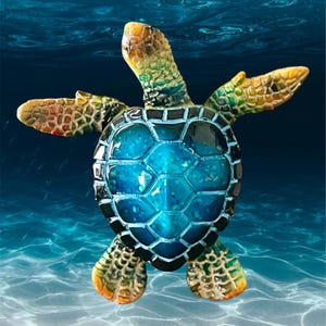May include: A colorful sea turtle figurine with a blue shell and a white background. The turtle is swimming in the ocean.