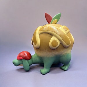 Puede incluir: Escultura de tortuga de cerámica caprichosa. Cuerpo redondo, marrón con remolinos crema. Cabeza y patas verdes, caparazón rojo. Diseño artístico y original, con estética lúdica.