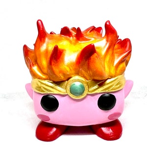 May include: A pink and red figurine with a yellow and orange flame-shaped head. The figurine has a gold crown with a green gem.