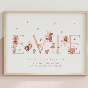 May include: A framed wall print featuring the name EVIE in large pink letters decorated with watercolour illustrations of fairies, mushrooms, flowers, bees, and stars. Below, the text reads EVIE GRACE SPARKES, BORN 14TH FEBRUARY 2024, AT 10.32 AM, WEIGHING 7LBS 9OZ.