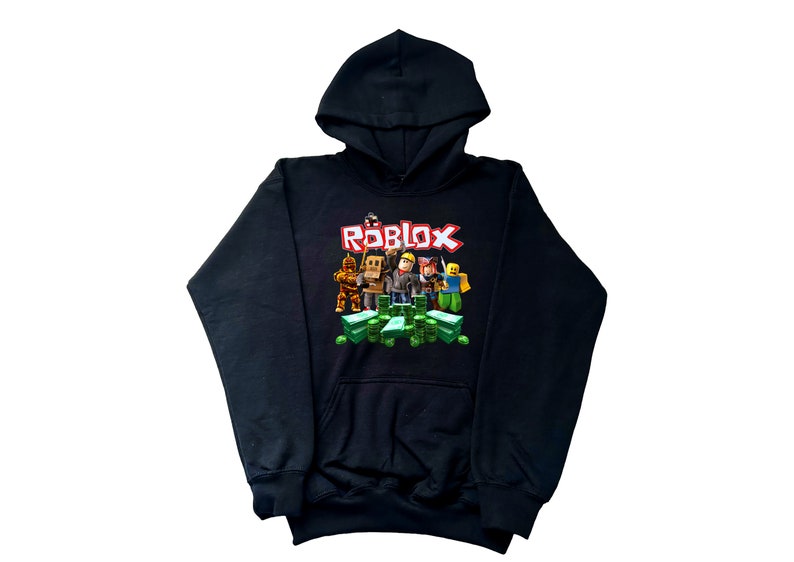 May include: Black hoodie with a graphic print of Roblox characters standing on stacks of money. The text "ROBLOX" is printed in red letters above the characters.