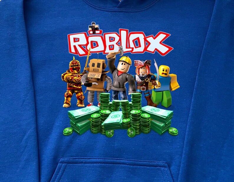 May include: Blue hooded sweatshirt with a graphic print of the word "ROBLOX" in white and red letters. The graphic also features five cartoon characters from the game Roblox standing in front of stacks of green money.