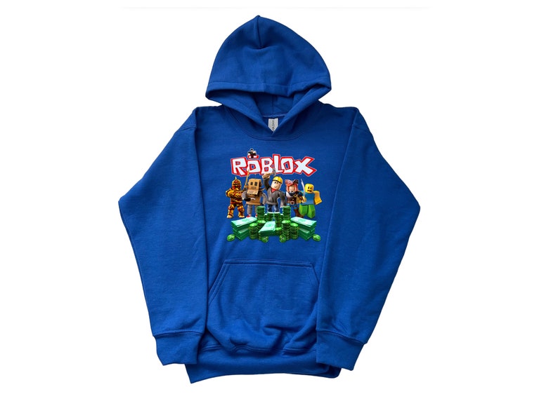 May include: A royal blue hooded sweatshirt with a graphic print of Roblox characters standing on a pile of green cash. The text "ROBLOX" is printed in red letters above the characters.