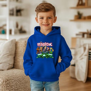 May include: A blue hooded sweatshirt with a graphic of Roblox characters and the word "Roblox" in white letters.