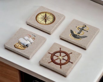 May include: Set of four square stone coasters with nautical themes. Each coaster features a different design: a compass, an anchor, a ship, and a ship's wheel.