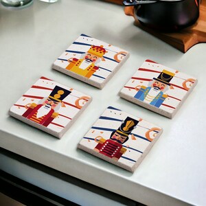 May include: Set of four square coasters featuring a whimsical Nutcracker theme. Each coaster has a different Nutcracker design with red, blue, yellow, and white accents on a white background with blue and red stripes.