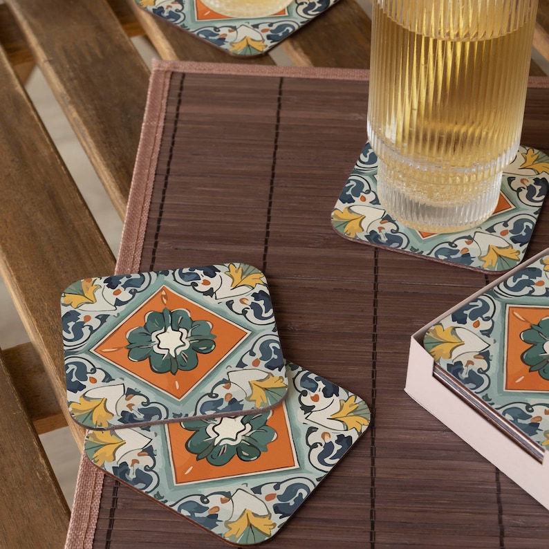 Puede incluir: Conjunto de cuatro posavasos cuadrados con un patr&oacute;n de azulejos coloridos. Los posavasos presentan un dise&ntilde;o azul, verde, naranja y amarillo. Los posavasos est&aacute;n sobre una estera de bamb&uacute; marr&oacute;n.
