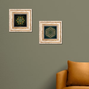 May include: Two framed prints with geometric designs in shades of green, gold, and black. The frames are white with gold accents.