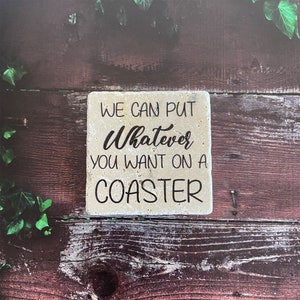Può includere: Un sottobicchiere in pietra beige con il testo "We can put Whatever you want on a COASTER" in lettere nere.
