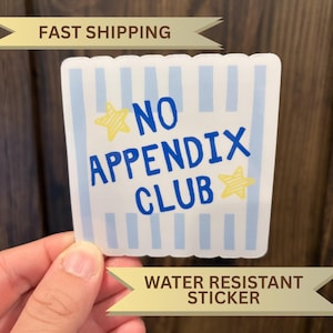 May include: A square sticker with scalloped edges featuring a light blue and white vertical striped background. The text NO APPENDIX CLUB is printed in bold blue letters, accompanied by two yellow hand-drawn style stars on the sides.