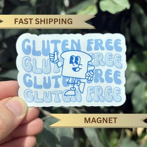 May include: A light blue sticker with the words "GLUTEN FREE" repeated multiple times. A cartoon bread slice character with a thumbs up is in the center. The word "MAGNET" is at the bottom.