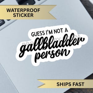 Könnte beinhalten: Ein weißer Aufkleber mit schwarzem Text, der "Guess I'm not a gallbladder person" lautet.