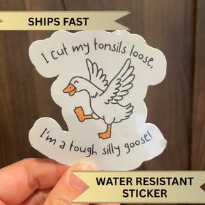 May include: White sticker featuring a cartoon goose and the text "I cut my tonsils loose, I'm a tough silly goose!" The sticker is water resistant.