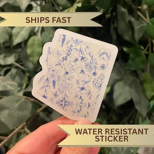 May include: A clear, water-resistant sticker featuring a blue floral design. The sticker has a white border and the text "WATER RESISTANT STICKER". The sticker is held in a hand, with the text "SHIPS FAST" in the background.