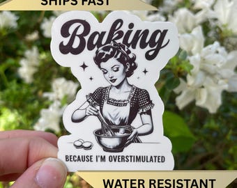 May include: A die-cut sticker featuring a black and white illustration of a person in an apron mixing ingredients in a bowl. The text reads Baking at the top and BECAUSE I'M OVERSTIMULATED at the bottom, with small star accents.