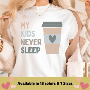 May include: White t-shirt with the text "My kids never sleep" and a cartoon coffee cup with a heart on it. Available in 13 colours and 7 sizes.