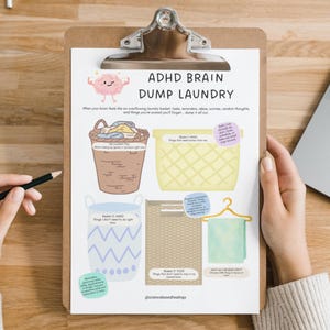 Può includere: Un foglio di lavoro stampabile ADHD Brain Dump Laundry su una cartellina. Presenta un'illustrazione di un cervello rosa, un cesto della biancheria marrone, un cesto giallo, un cesto blu a motivi, un contenitore beige e un asciugamano verde.