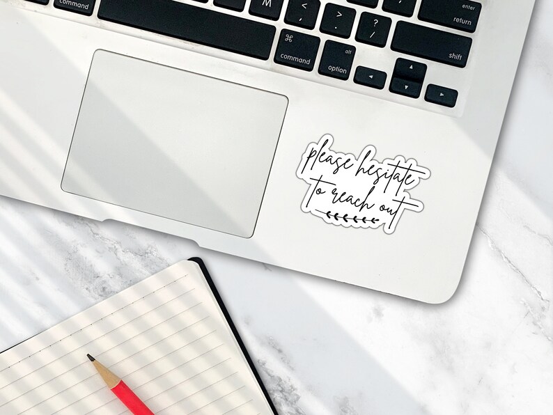 May include: A white laptop computer with a black keyboard and a sticker that says "Please hesitate to reach out" with a small line of leaves underneath the text.