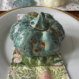 Calabazas decorativas de cerámica de color blanco, calicó, azul, naranja y bronce verde.