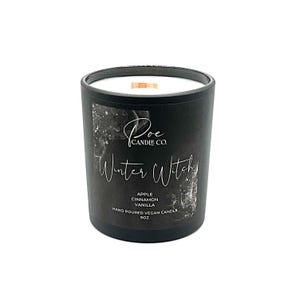 以下が含まれることがあります： 白いワックスと木製の芯が入った円筒形のガラス容器に入った黒いキャンドル。ラベルには、Poe Candle Co.、Winter Witch、Apple、Cinnamon、Vanilla、Hand Poured Vegan Candle、9ozという文字が白いスクリプトとプリントで記されています。