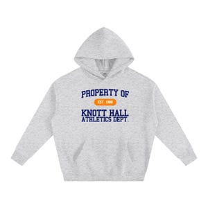May include: A light gray hoodie with a front pocket and a hood. The front of the hoodie features the text "PROPERTY OF" above "KNOTT HALL ATHLETICS DEPT." in navy blue, with "EST. 1988" in an orange oval.
