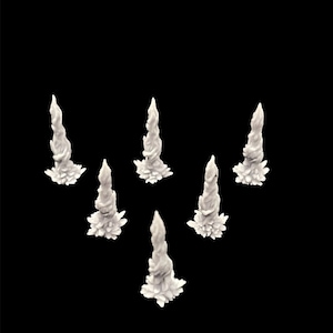 May include: Six white, abstract sculptures, resembling candles, are set against a black backdrop. Each has a textured, elongated shape with a floral base. The lighting creates shadows, enhancing the three-dimensional effect.