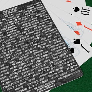 May include: Poker chips in red, black, and blue are stacked on a green felt surface. Playing cards with the number 10 are visible, along with a card with the word "DOUBLTAKE" and other text.