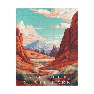 May include: A jigsaw puzzle featuring a scenic landscape of Valley of Fire State Park in Nevada. The puzzle depicts red rock formations, a winding road, and a mountain range under a blue sky with clouds. The text "Valley of Fire State Park" is at the bottom.