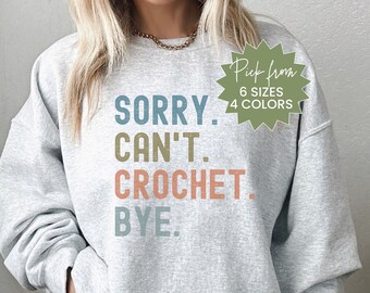 May include: Gray sweatshirt with the text "SORRY. CAN'T. CROCHET. BYE." in colorful block letters. The text is in a vintage style font. The sweatshirt is available in 6 sizes and 4 colors.
