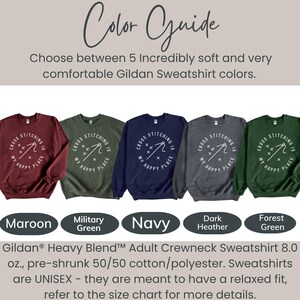 May include: A color guide for Gildan Heavy Blend adult crewneck sweatshirts. The image shows five sweatshirts in different colors: maroon, military green, navy, dark heather, and forest green. Each sweatshirt has a white graphic that says "Cross Stitching is My Happy Place".
