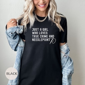 May include: Black t-shirt with the text "Just a girl who loves true crime and needlepoint" and a needle and thread design.