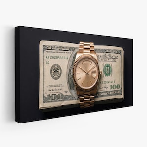 Op de afbeelding: Een goudkleurig polshorloge ligt op een stapel honderd dollar biljetten. Het horloge heeft een ronde wijzerplaat en een gouden band. De bankbiljetten tonen de tekst "FEDERAL RESERVE NOTE" en "UNITED STATES OF AMERICA".