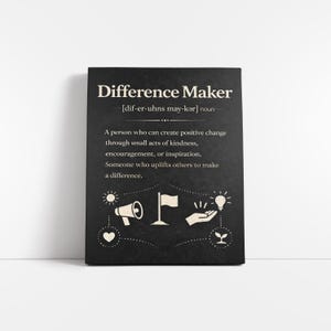 Può includere: Un cartello rettangolare nero con le parole "Difference Maker" in bianco. La definizione di "Difference Maker" è stampata sotto il titolo. Il cartello presenta anche icone grafiche bianche di un megafono, una bandiera, una lampadina e un cuore.