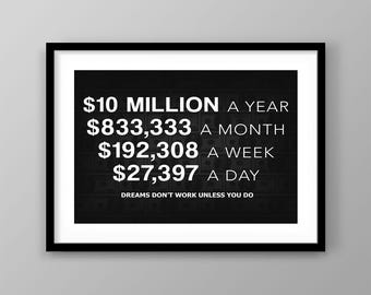 May include: A framed black and white print with the text "$10 MILLION A YEAR, $833,333 A MONTH, $192,308 A WEEK, $27,397 A DAY". The phrase "DREAMS DON'T WORK UNLESS YOU DO" is at the bottom.