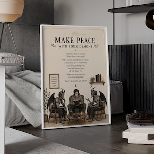 Può includere: Una stampa artistica rettangolare su sfondo beige con il testo "MAKE PEACE WITH YOUR DEMONS" sopra una poesia. L'illustrazione mostra una persona seduta tra due figure alate con le corna su poltrone attorno a un tavolino con dei libri.