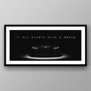 May include: Monochrome framed print showing the front of a car, lit by headlights. The text "IT ALL STARTS WITH A DREAM" is above the car. The image is set against a dark background.