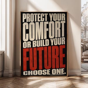 May include: A rectangular wall art print featuring a black background with bold, capitalised text. The words "PROTECT YOUR COMFORT OR BUILD YOUR" appear in off-white, while the word "FUTURE" is in large red letters, followed by "CHOOSE ONE." in white.