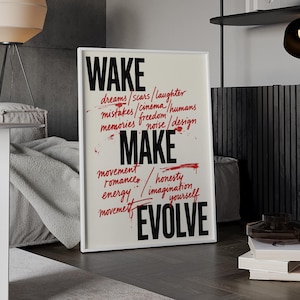Könnte beinhalten: Ein rechteckiges gerahmtes Wandbild mit den fettgedruckten schwarzen Wörtern WAKE, MAKE und EVOLVE. Dazwischen befinden sich kleinere, handschriftlich wirkende rote Wörter wie dreams, scars, laughter, mistakes, cinema, humans, memories, freedom, noise, design, movement, romance, honesty, imagination und yourself, ergänzt durch rote Farbspritzer.