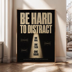 Può includere: Un poster rettangolare con sfondo nero e testo dorato. In alto si legge BE HARD TO DISTRACT. Sotto, un effetto riflettore evidenzia le parole ONE GOAL, ONE TASK, ONE HOUR. Le parole barrate includono NOTIFICATIONS, OPINIONS e URGENCY.