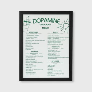 May include: A framed print with a black border features a green and white "Dopamine Menu." The menu lists appetizers, entrees, sides, desserts, and specials, with activities like "5-min gratitude journal" and "watch a movie." A sun illustration is in the upper right.