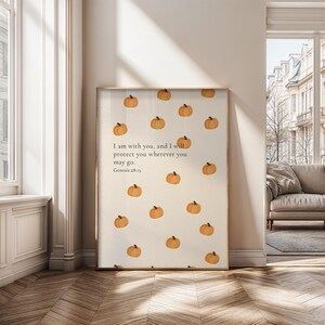 May include: A framed print featuring a beige background with scattered orange pumpkin illustrations. The print includes the text "I am with you, and I will protect you wherever you may go. Genesis 28:15."