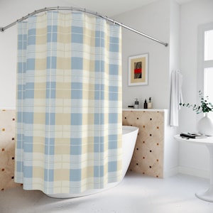 May include: A blue and cream plaid shower curtain hangs in a bathroom with a white bathtub and tiled walls.