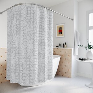 May include: White shower curtain with a black and white puzzle piece pattern. The curtain is hung on a curved shower rod and is partially pulled back to reveal a white bathtub.