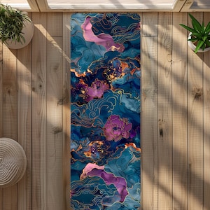 May include: A yoga mat featuring an abstract floral design in shades of blue, purple and gold. The design incorporates stylised flowers and swirling lines.