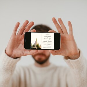 K&ouml;nnte beinhalten: Eine Person h&auml;lt ein Smartphone, auf dem eine Hochzeitseinladung mit einem Foto eines Tempels und dem Text "Temple Sealing Nick & Kayla Oakland Temple" zu sehen ist.