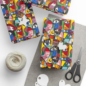 May include: Three gift boxes wrapped in colorful abstract patterned wrapping paper with a yellow background. The pattern features a variety of shapes and colors, including red, blue, green, and black. The boxes are tied with twine and decorated with white paper stars and hearts.